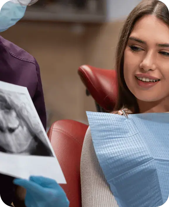 Patient looking at a dental X-ray before choosing between a bridge and an implant
